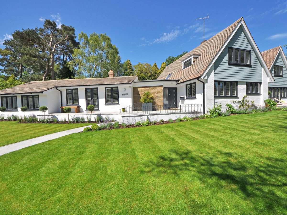 Well-maintained landscaped yard with a green lawn and trimmed shrubs